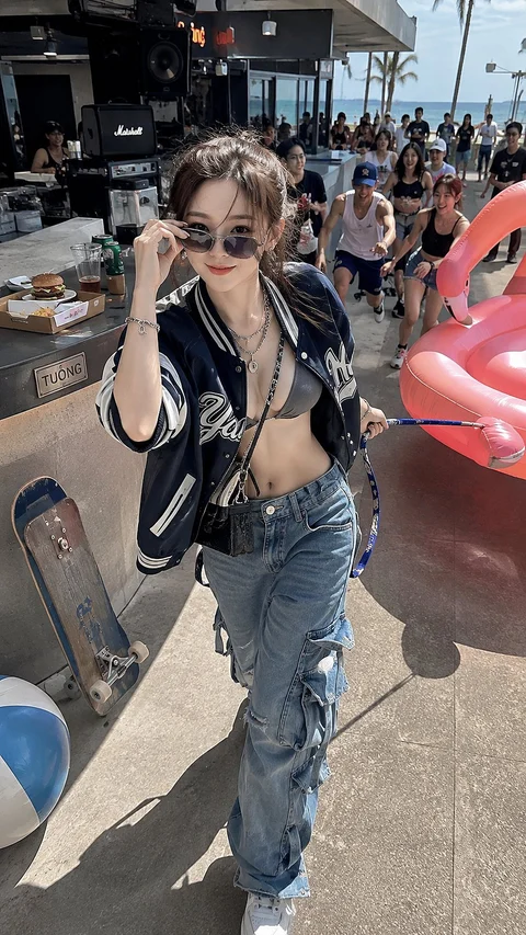 At an outdoor car event, a woman in sunglasses, a dark leather jacket and jeans poses beside cars and a crowd.